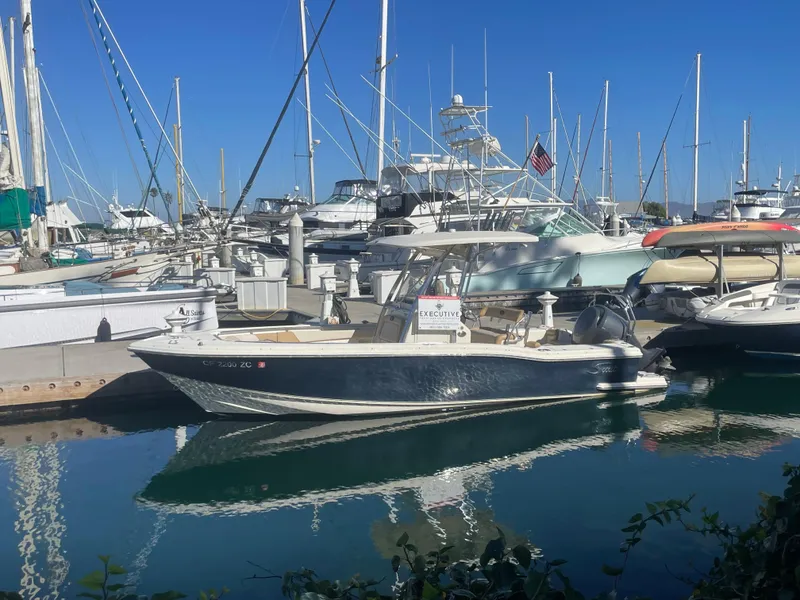 Slide: The Image of 2007 Scout 242 Sportfish boat docked in a marina with sailboats. - 2