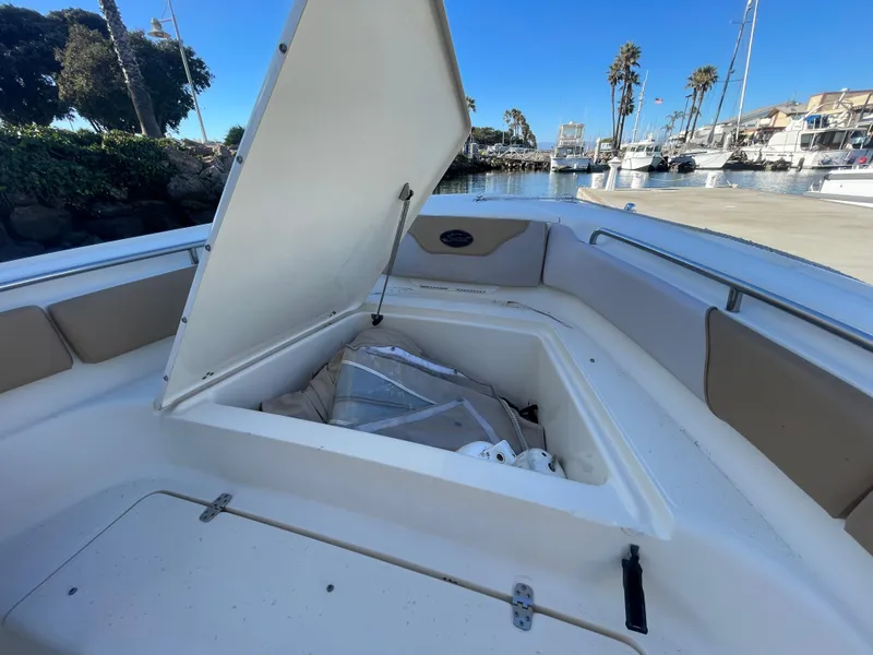 Slide: The Image of 2007 Scout 242 Sportfish boat with open storage compartment, docked in marina. - 24