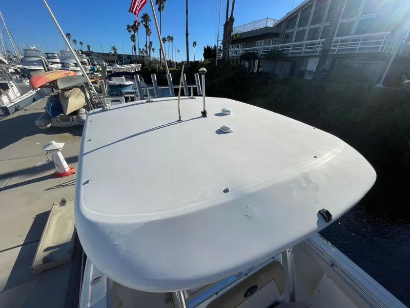 Slide: The Image of 2007 Scout 242 Sportfish boat docked at marina with American flag. - 27