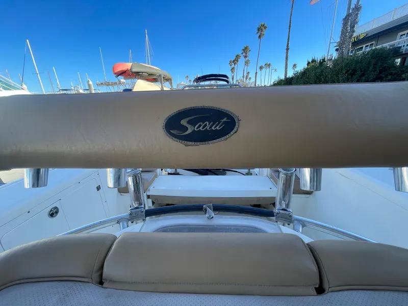 Slide: The Image of 2007 Scout 242 Sportfish boat interior with logo, docked under clear blue sky. - 33
