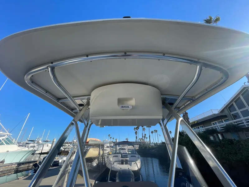 Slide: The Image of 2007 Scout 242 Sportfish boat with T-top, docked at marina under clear blue sky. - 35