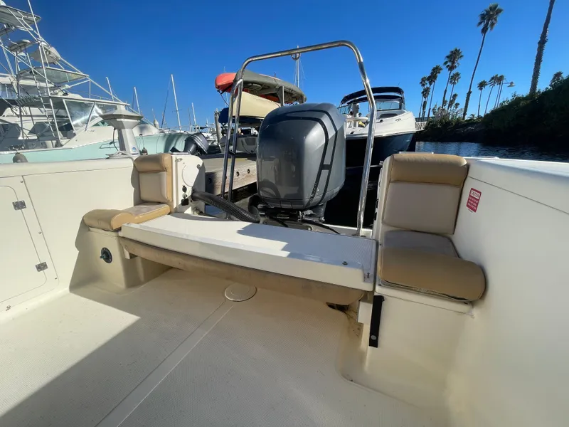 Slide: The Image of 2007 Scout 242 Sportfish boat with outboard motor, docked under clear blue sky. - 5