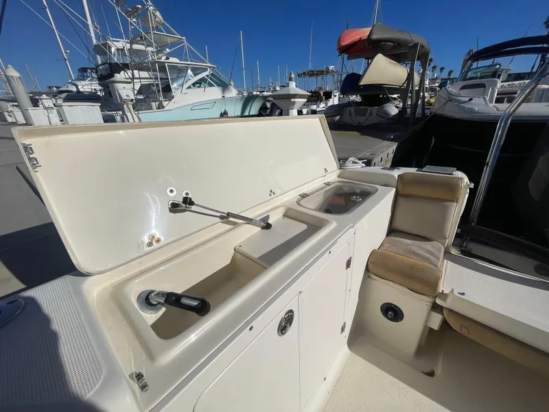 Slide: The Image of 2007 Scout 242 Sportfish boat interior with open storage and seating at marina. - 7
