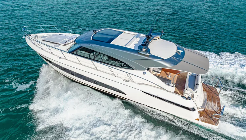 Slide: The Image of 2025 Riviera 5400 Sport Yacht cruising on open water. - 13