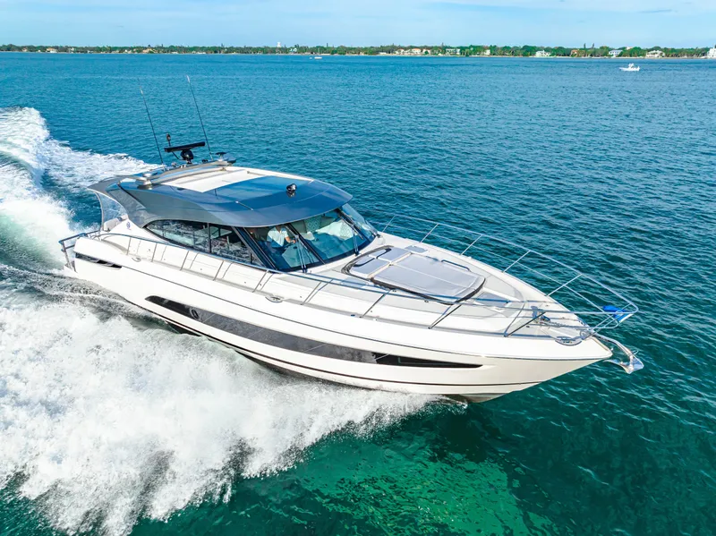 Slide: The Image of 2025 Riviera 5400 Sport Yacht cruising on open water. - 17