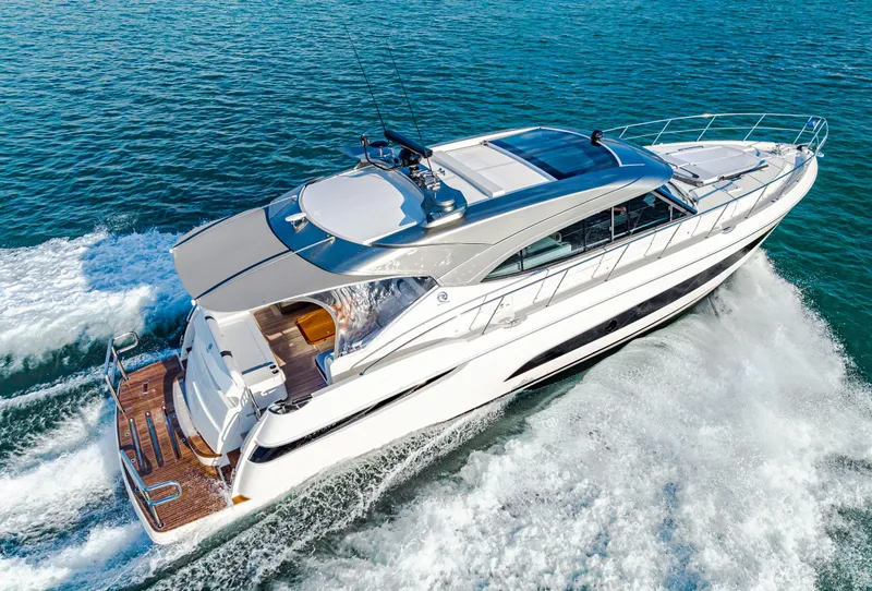 Slide: The Image of 2025 Riviera 5400 Sport Yacht cruising on open water, aerial view. - 23