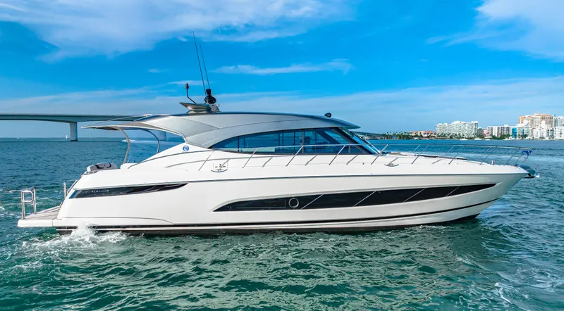 Slide: The Image of 2025 Riviera 5400 Sport Yacht cruising on open water under a clear blue sky. - 3
