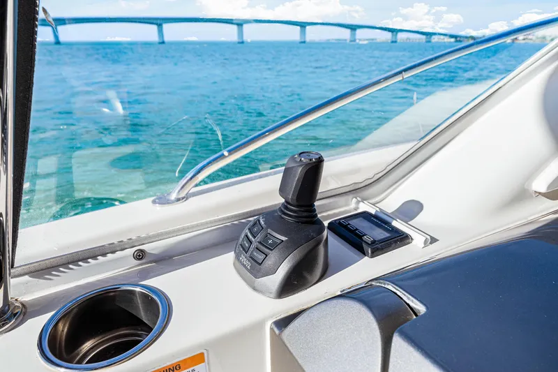 Slide: The Image of Riviera 5400 Sport Yacht 2025 helm with joystick control, ocean view, and bridge in background. - 34