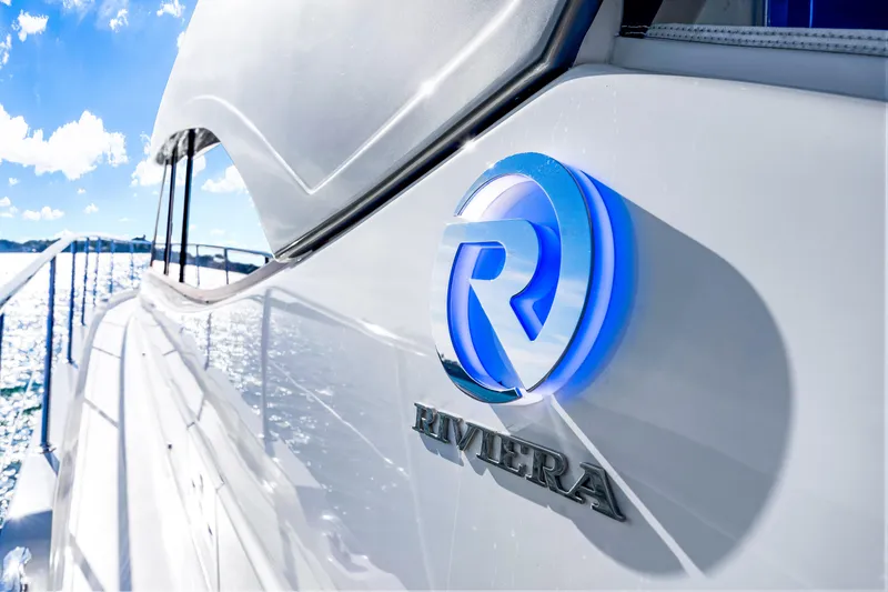 Slide: The Image of 2025 Riviera 5400 Sport Yacht with logo, cruising on sunny waters. - 39