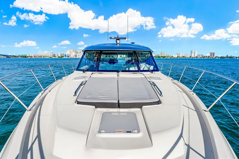 Slide: The Image of 2025 Riviera 5400 Sport Yacht cruising on a sunny day with city skyline in background. - 41