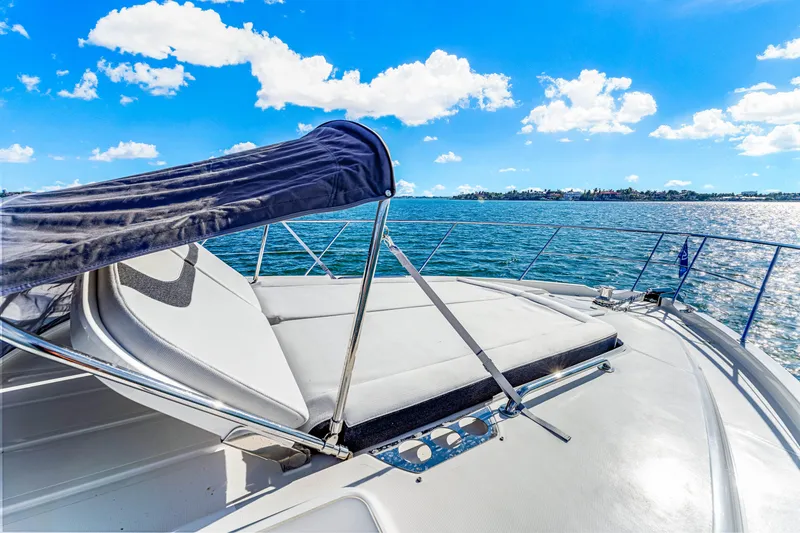 Slide: The Image of 2025 Riviera 5400 Sport Yacht on open water under clear blue sky. - 44