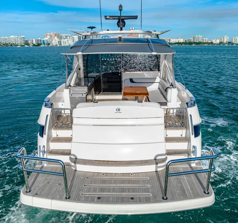 Slide: The Image of 2025 Riviera 5400 Sport Yacht cruising on open water, rear view. - 6