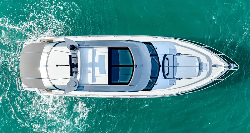 Slide: The Image of Aerial view of 2025 Riviera 5400 Sport Yacht cruising on turquoise water. - 7