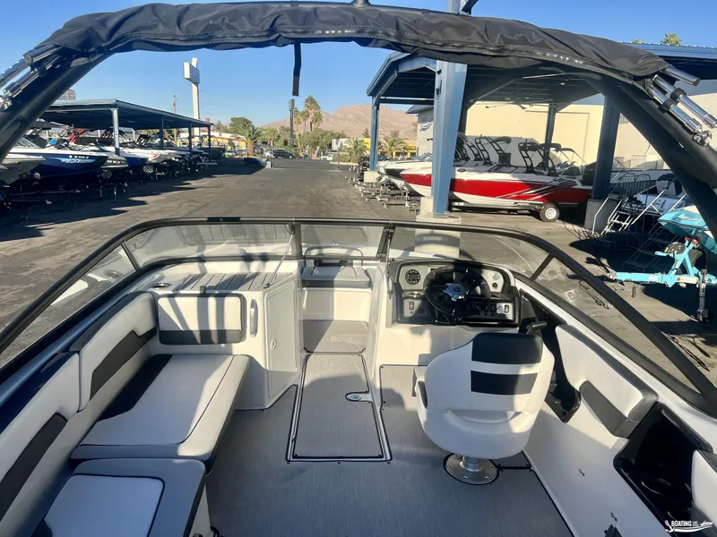 Slide: The Image of 2025 Yamaha AR195 boat interior with seating and steering wheel, displayed in a showroom. - 3