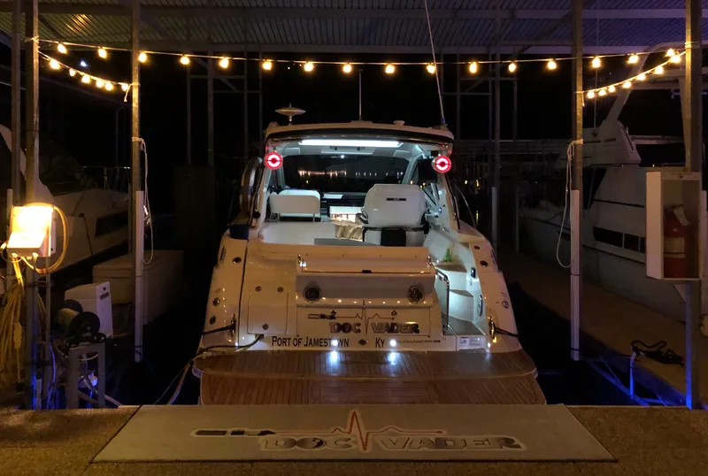 Slide: The Image of 2018 Sea Ray Sundancer 350 Coupe docked at night with string lights. - 14
