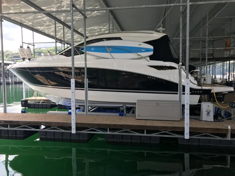 Slide: The Image of 2018 Sea Ray Sundancer 350 Coupe docked in a covered marina. - 2
