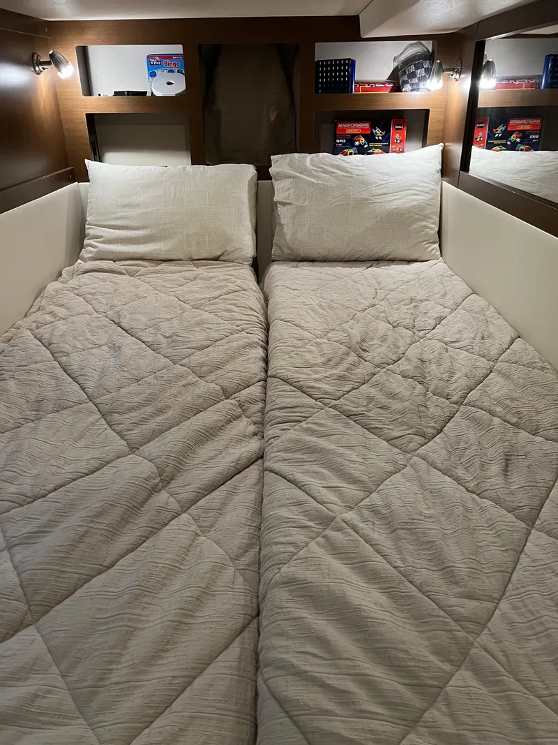 Slide: The Image of 2018 Sea Ray Sundancer 350 Coupe cabin with twin beds and cozy bedding. - 4