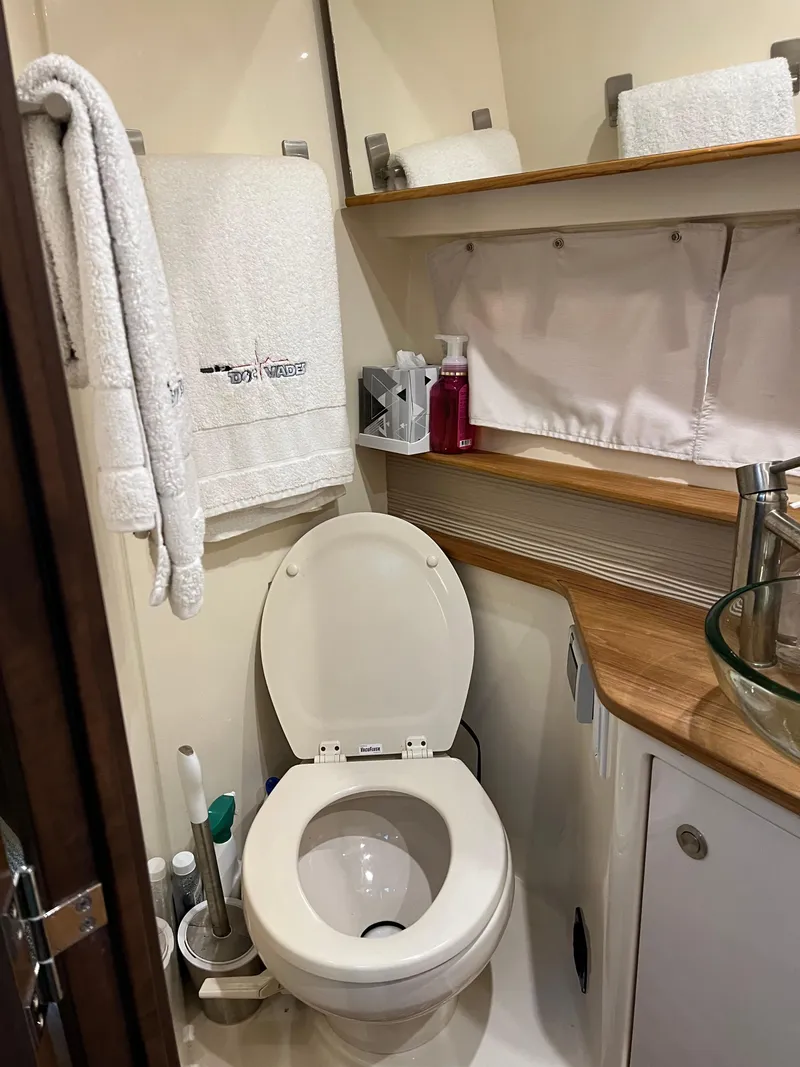 Slide: The Image of 2018 Sea Ray Sundancer 350 Coupe bathroom with modern amenities and wooden accents. - 6