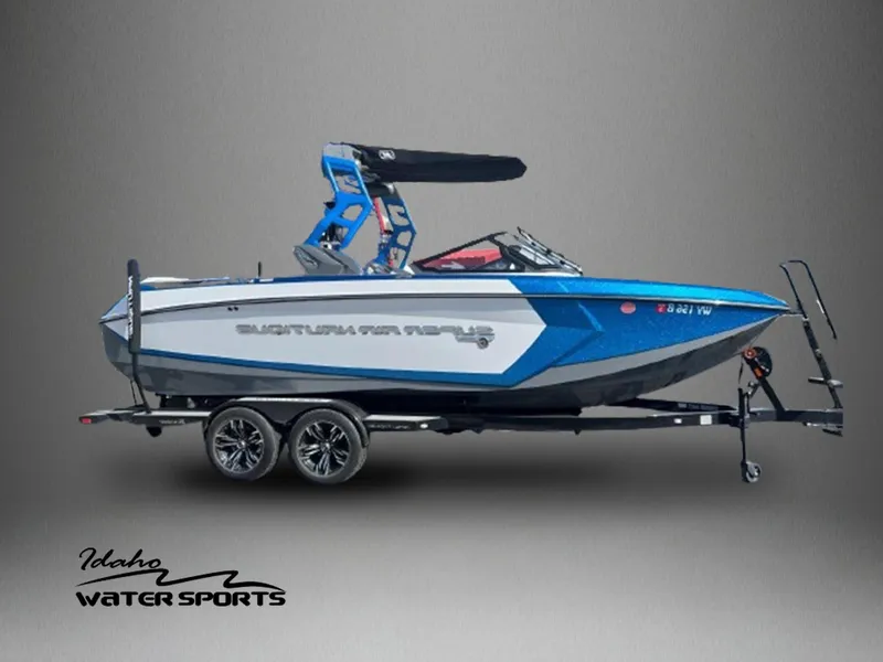 Slide: The Image of 2020 Nautique G23 boat on trailer, blue and white, Idaho Water Sports logo. - 1