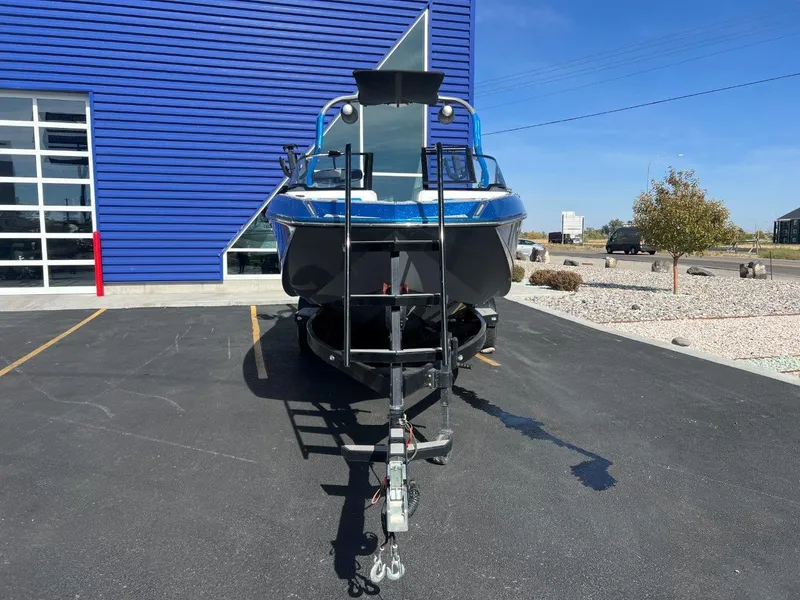 Slide: The Image of 2020 Nautique G23 boat on trailer, parked outside blue building. - 10