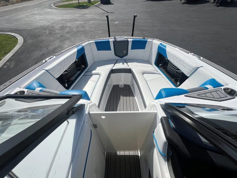 Slide: The Image of 2020 Nautique G23 boat interior with white and blue seating, open bow design. - 18