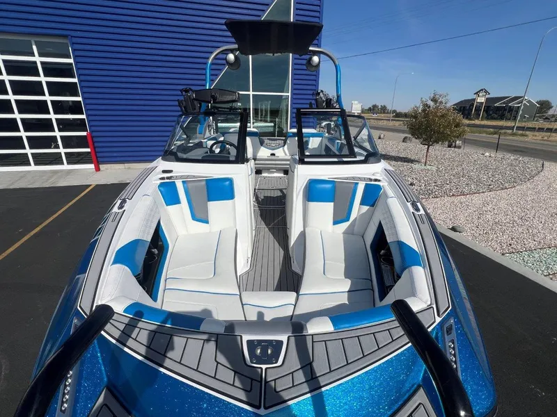 Slide: The Image of 2020 Nautique G23 boat with blue and white interior, parked outdoors. - 19