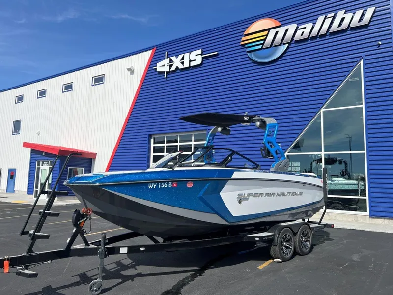 Slide: The Image of 2020 Nautique G23 boat on trailer outside Malibu dealership. - 2