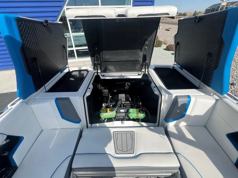 Slide: The Image of 2020 Nautique G23 boat engine compartment with open hatches, showcasing interior details. - 21
