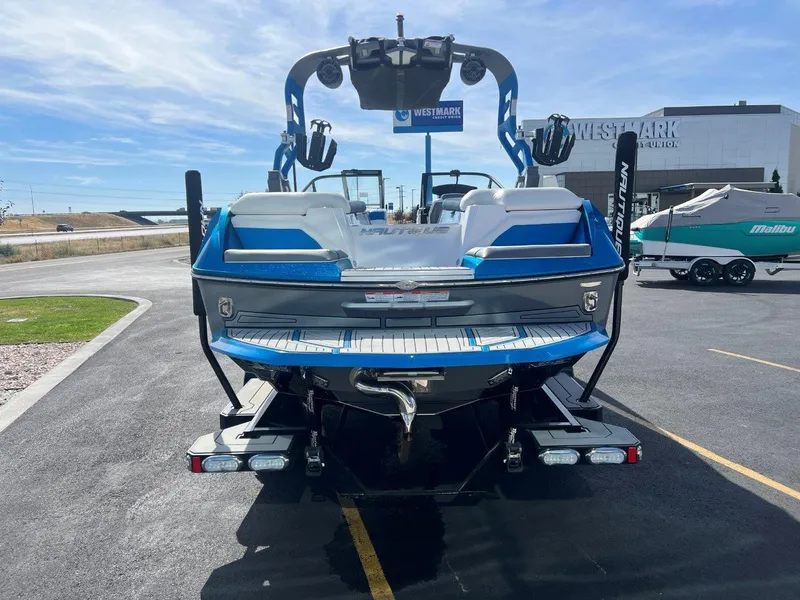 Slide: The Image of 2020 Nautique G23 boat, blue and white, parked outdoors at dealership. - 6