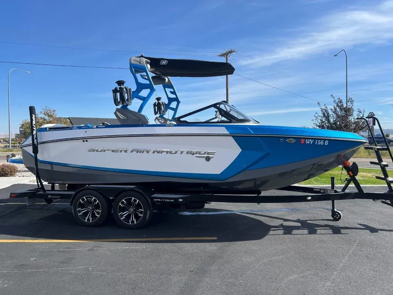 Slide: The Image of 2020 Nautique G23 boat on trailer, blue and white design, parked outdoors. - 8