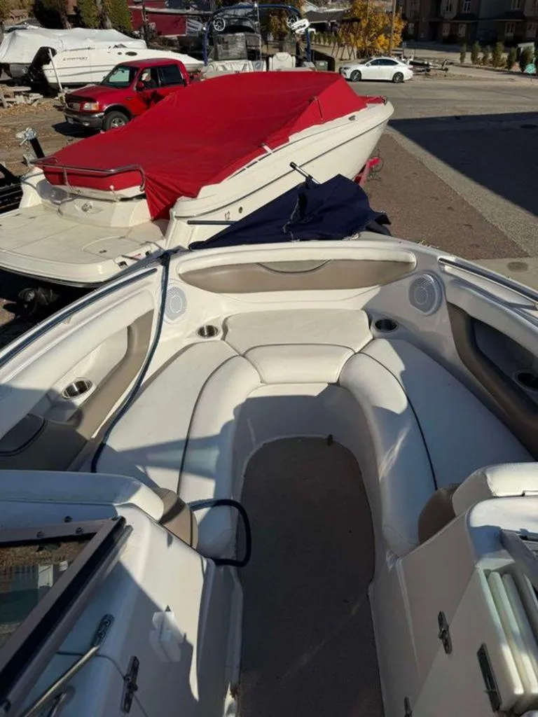Slide: The Image of 2004 Four Winns 230 Horizon boat with red cover, parked outdoors. - 2