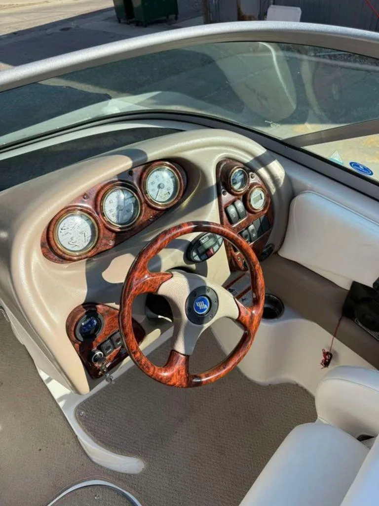 Slide: The Image of 2004 Four Winns 230 Horizon boat dashboard with wood accents and steering wheel. - 3