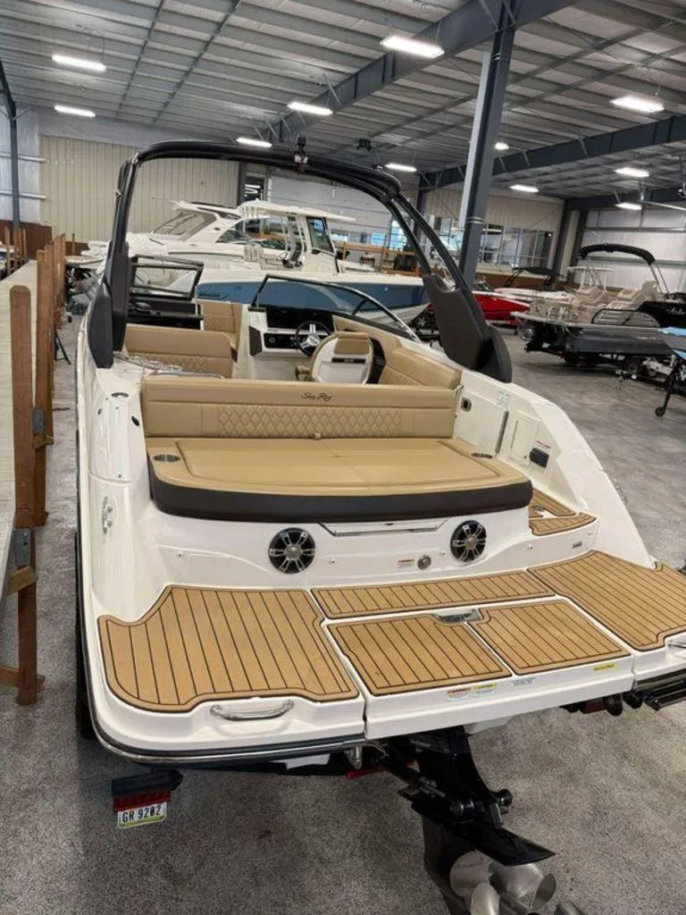 Slide: The Image of 2019 Sea Ray SLX 230 boat in showroom, featuring tan seating and teak-style decking. - 4