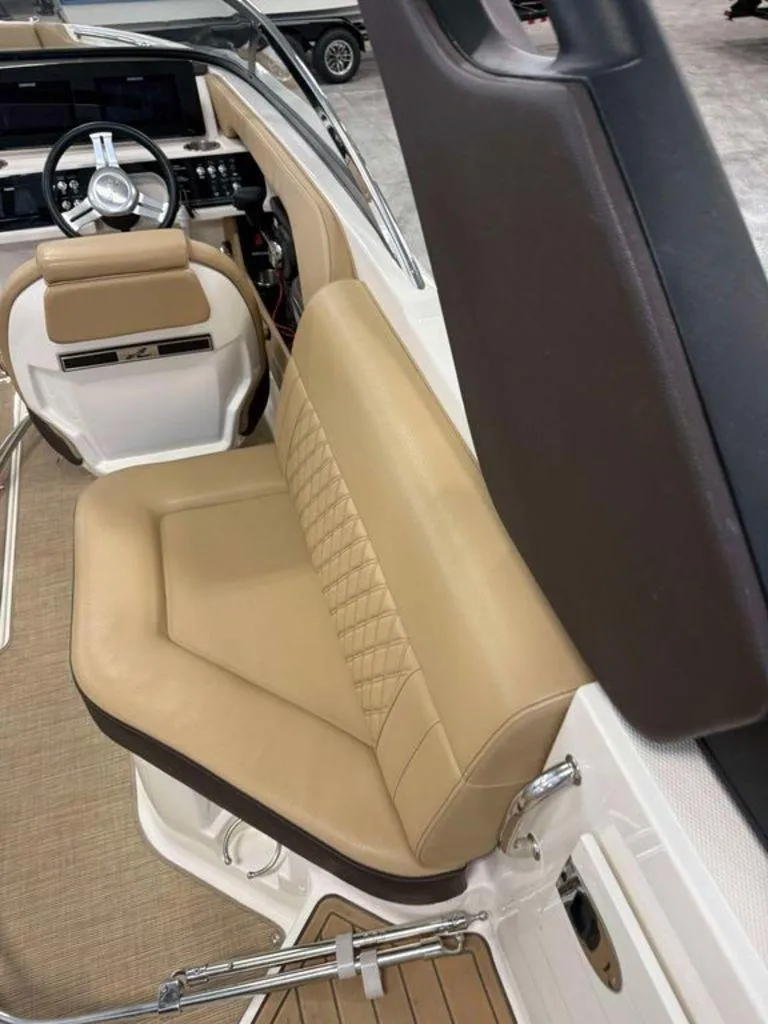 Slide: The Image of 2019 Sea Ray SLX 230 boat interior with tan leather seating and modern dashboard. - 5