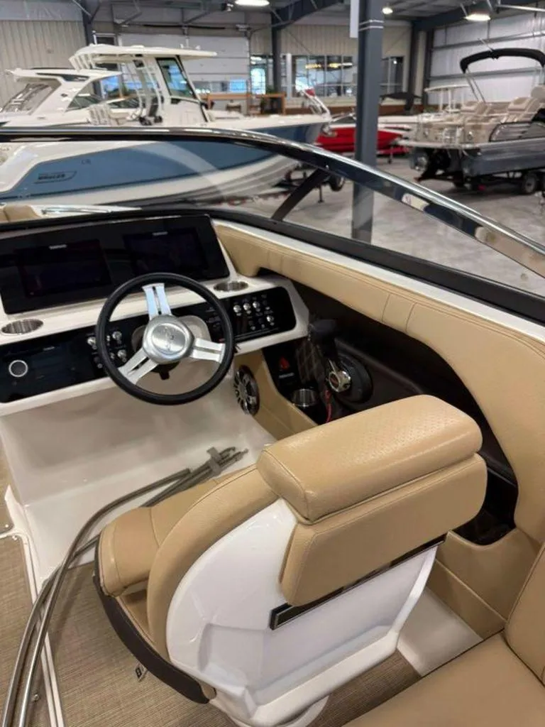Slide: The Image of Interior of 2019 Sea Ray SLX 230 boat with beige seating and modern dashboard. - 7