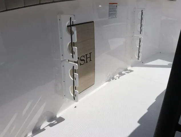 Slide: The Image of 2025 Yamaha Boats 255 FSH SPORT H-SEAFOAM G interior with beige seating and table. - 13