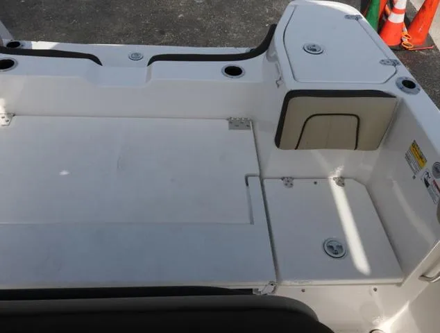 Slide: The Image of 2025 Yamaha Boats 255 FSH SPORT H-SEAFOAM G deck, featuring storage compartments and sleek design. - 25