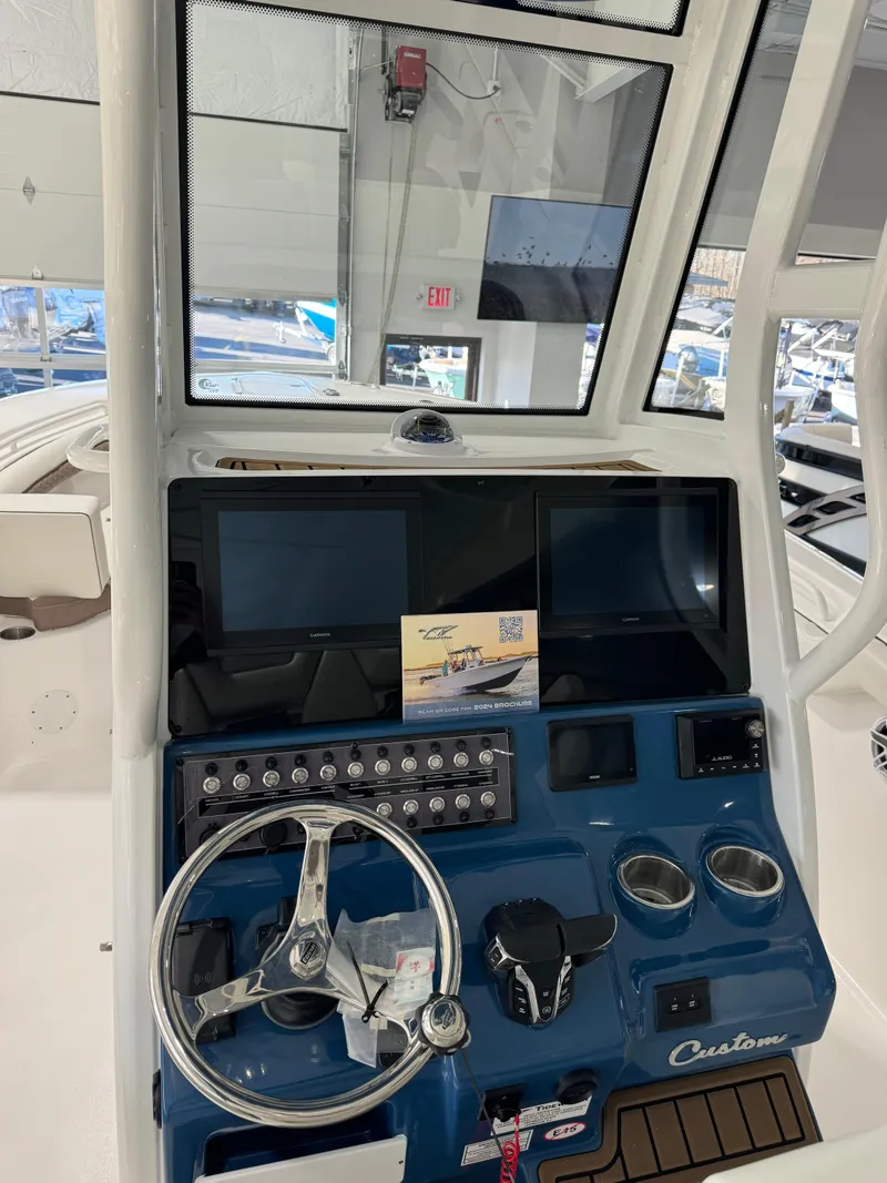 Slide: The Image of 2024 Tidewater 272 CC Adventure boat dashboard with steering wheel and controls. - 5