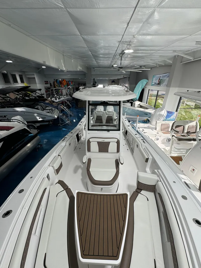 Slide: The Image of 2024 Tidewater 272 CC Adventure boat in showroom, featuring sleek design and spacious seating. - 7
