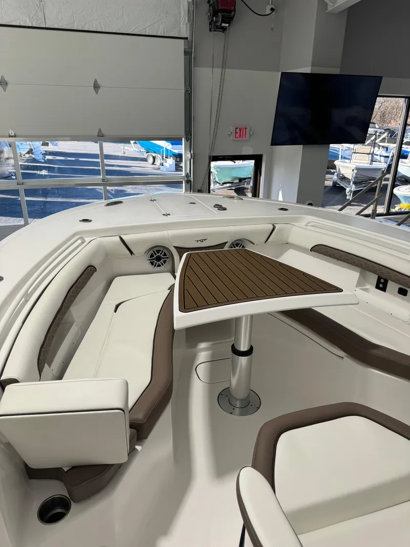 Slide: The Image of 2024 Tidewater 272 CC Adventure boat interior with seating and table. - 8