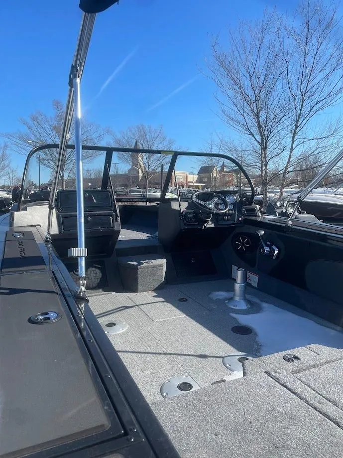 Slide: The Image of 2025 Tracker Targa V-19 Combo boat interior with steering wheel, seats, and clear blue sky. - 2