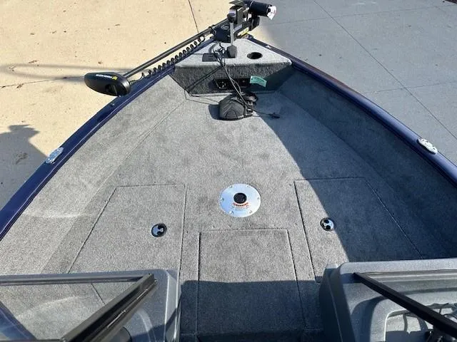 Slide: The Image of 2025 Tracker Pro Guide V-175 Combo boat interior with carpeted deck and trolling motor. - 4