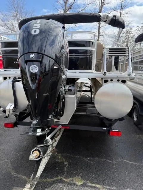 Slide: The Image of 2025 Sun Tracker SportFish 22 XP3 boat with powerful outboard motor, parked outdoors. - 2