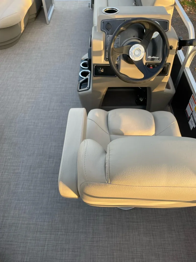 Slide: The Image of 2025 Sun Tracker Party Barge 16 DLX interior with steering wheel and seating. - 45