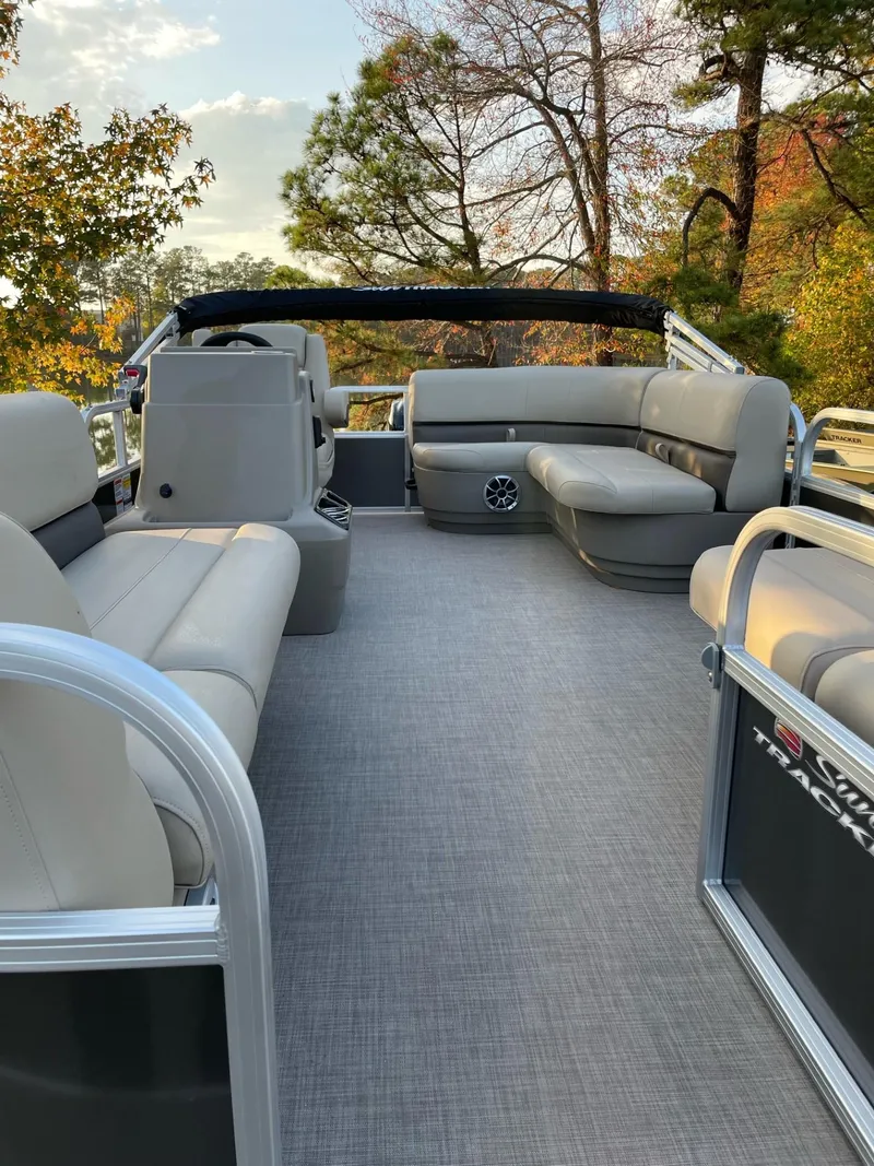 Slide: The Image of 2025 Sun Tracker Party Barge 16 DLX pontoon boat with spacious seating and scenic background. - 46