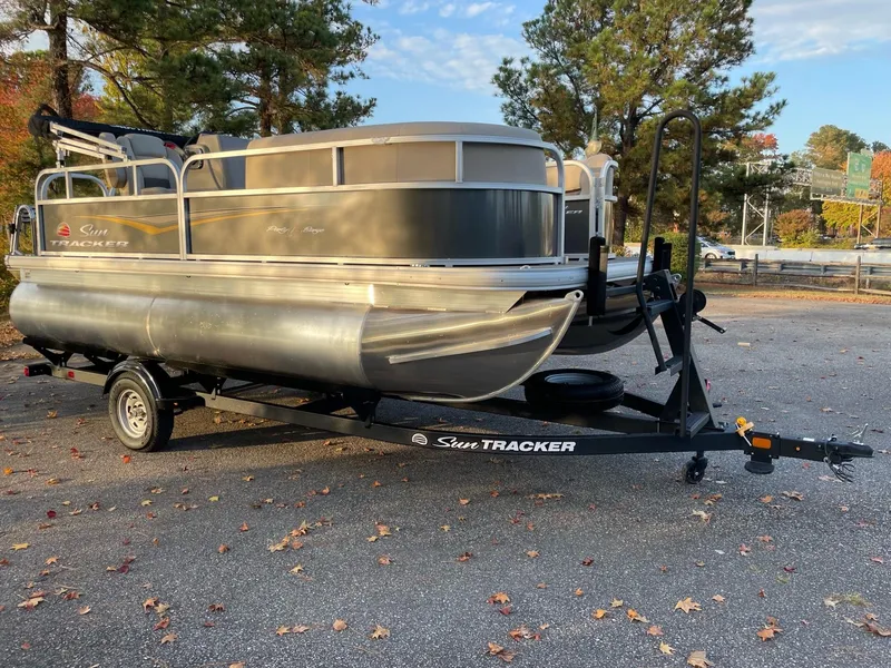 Slide: The Image of 2025 Sun Tracker Party Barge 16 DLX pontoon boat on trailer in parking lot. - 47