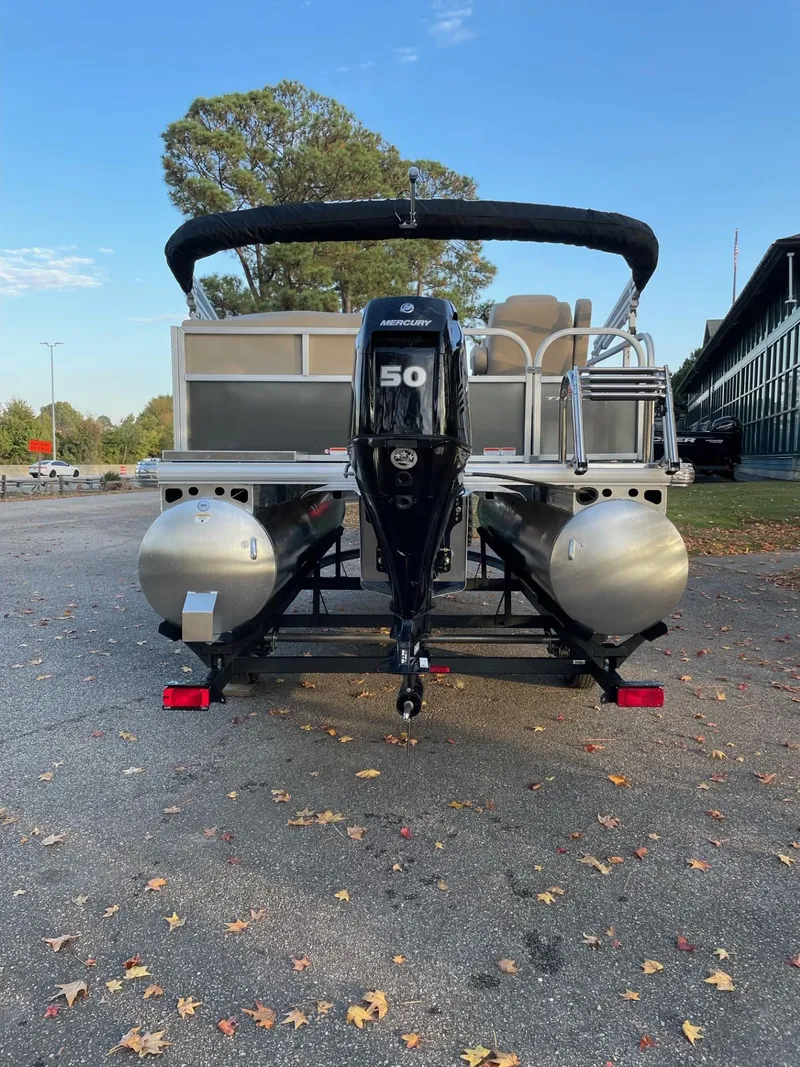 Slide: The Image of 2025 Sun Tracker Party Barge 16 DLX pontoon boat with 50 HP engine, parked outdoors. - 49