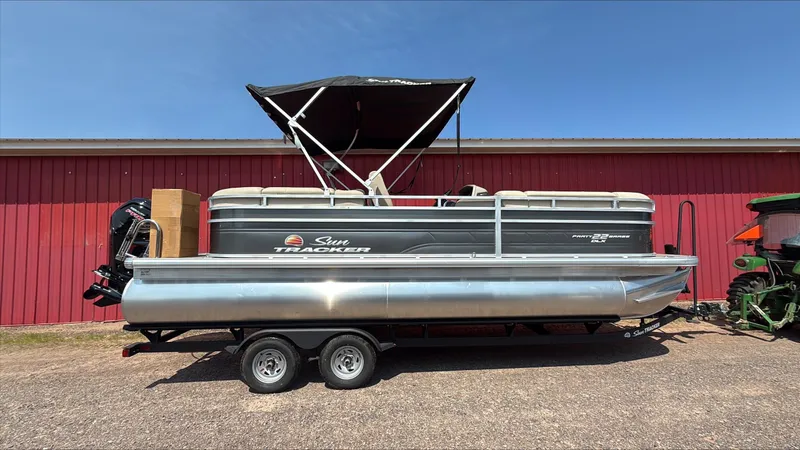 The Image of 2025 Sun Tracker Party Barge 22 DLX pontoon boat parked outdoors. - 0