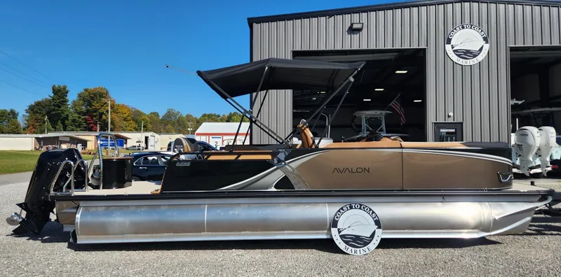 Slide: The Image of 2025 Avalon Platinum LSZ 2385 Cruise Rear Bench pontoon boat outside a showroom. - 0