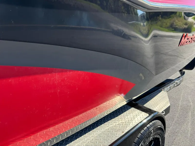 Slide: The Image of 2014 MasterCraft X46 boat with red and black exterior on a trailer. - 13